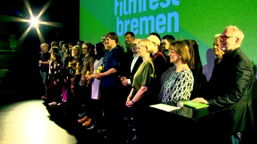 Auf einer Bühne beim Bremer Filmfest stehen die ganzen Preisträgerinnen und Preisträger.