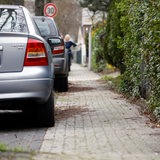 Autos parken teilweise auf einem Gehweg