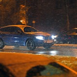 Ein Auto fährt bei Schnee und Glätte über eine Straße