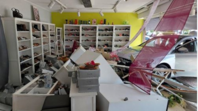 Ein Auto ist durch das Schaufenster in ein Schuhgeschäft gefahren.