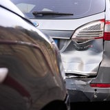 Nach einem Unfall ist die Rückseite eines Autos zerbeult.