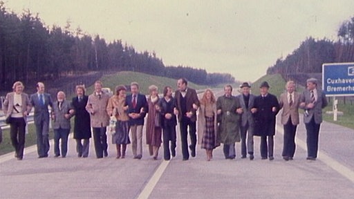 Menschenkette auf der leeren Autobahn A27