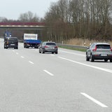 Wenige Autos fahren auf einer ansonsten leeren Autobahn.
