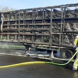 Ein ausgebrannter Lkw-Anhänger steht auf einer Autobahn.