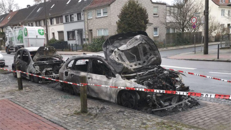 Zwei völlig ausgebrannte Fahrzeuge stehen in Findorff durch ein Absperrband gesichert an einer Straße