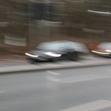 Zwei Fahrzeuge überholen sich auf einer Landstraße.