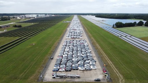 Tausende Neuwagen von Mercedes parken auf einer Landebahn eines Flugplatzes.