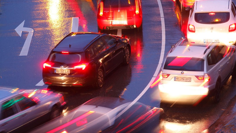 Autos fahren bei Dunkelheit über eine Straße.