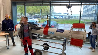 Ein Mann steht vor dem Messgerät Icebird im Technikum des AWI in Bremerhaven