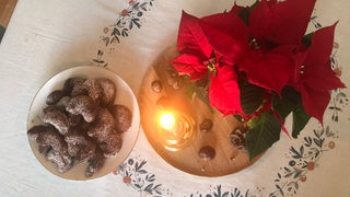 Schoko-Vanillekipferl stehen auf einem Tisch neben einem Weihnachtsstern