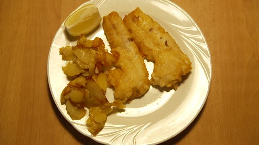 Ein Teller mit Backfisch und Bratkartoffeln
