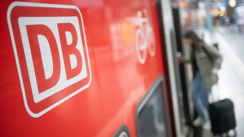 Eine Frau steigt in einen Regionalexpress ein. 