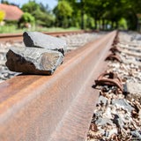 Auf den Schienen einer Bahnstrecke liegen zwei Steine.