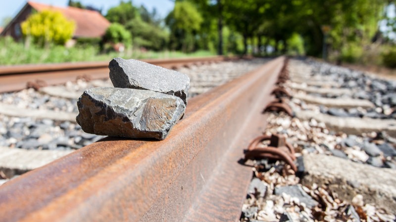 Auf den Schienen einer Bahnstrecke liegen zwei Steine.