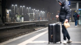 Ein Reisender steht am frühen Morgen am Bremer Hauptbahnhof. Die Gewerkschaft Deutscher Lokomotivführer (GDL) hat ab Mitte der Woche zum ersten mehrtägigen Streik im aktuellen Tarifkonflikt mit der Deutschen Bahn und anderen Unternehmen aufgerufen.