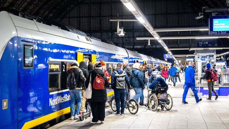 Reisende steigen am Bremer Hauptbahnhof in einen Zug.