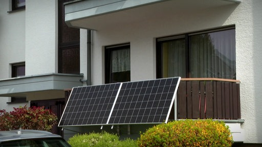 Zwei Solarpanels am Geländer eines Balkons. 