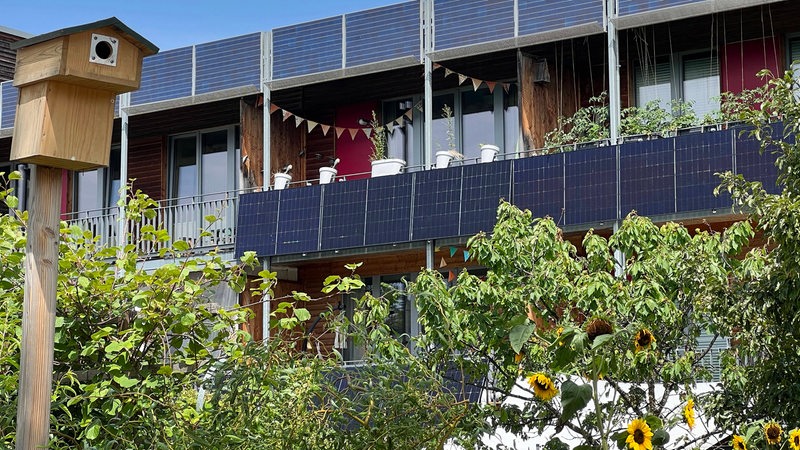 Solarpanels sind am Balkongeländer von Wohnungen montiert. 