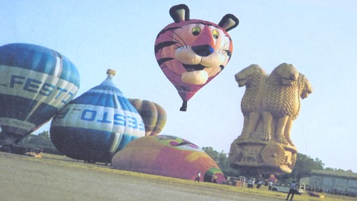 Verschiedene Heißluftballons am Boden und in der Luft.