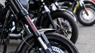 Mehrere Motorräder stehen in einer Reihe, auf einem steht "Bandidos".