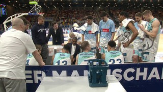 Die Basketball-Spieler der Eisbären Bremerhaven stehen bei einer Auszeit um Coach Steven Key herum.