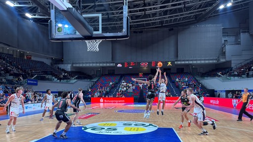 Ein Basketballer der Eisbären Bremerhaven wirft im Sprung auf den Korb.