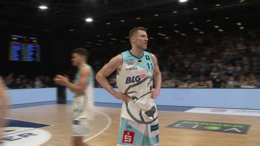 Der Basketballspieler Robert Öhle steht auf dem Basketballspielfeld in der Stadthalle.