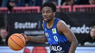 Basketballer Elijah Miller von den Eisbären Bremerhaven hat den Ball an der Hand und dribbelt.