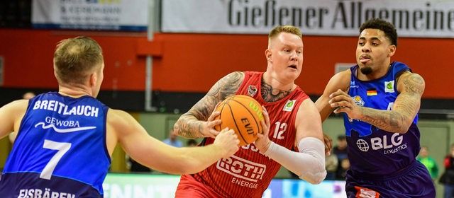 Die Basketballer Adrian Breitlauch und Jordan Samare von den Eisbären Bremerhaven versuchen, Gießens Robin Benzing zu stoppen
