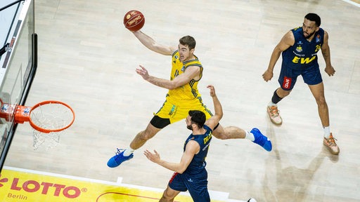 Ein Basketballer von Alba Berlin springt hoch und setzt zum Korbleger an.