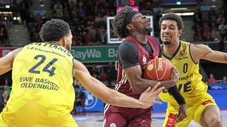 Münchens Basketballer Sylvain Francisco klammert den Ball an den Körper im Zweikampf mit Deane Williams von den Baskets Oldenburg.