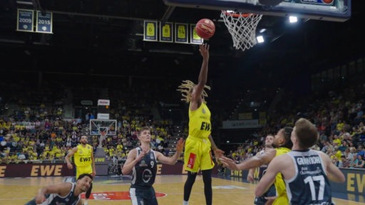 Ein Spieler der Baskets Oldenburg macht bei einem Spiel einen Korb für seine Mannschaft.