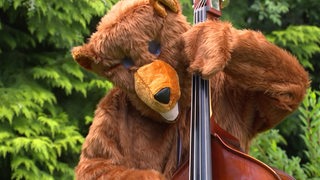 Larissa Raumann spielt Kontrabass in einem Bärenkostüm.