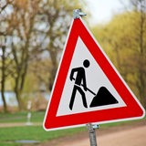 Ein Baustellenschild steht an einem Weg.