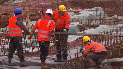 Bauarbeitende auf einer Baustelle.