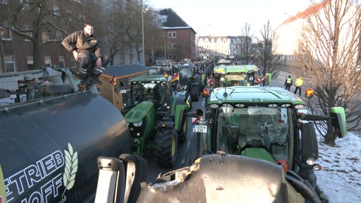 Zu sehen sind mehrere Traktoren, die eine Straße blockieren.