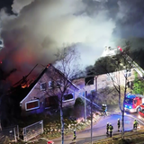Mehrere Feuerwehrleute löschen einen Brand in einem Bauernhaus in Zeven.