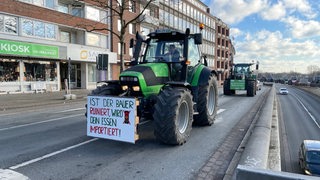 Zwei Traktoren mit Protestplakaten stehen am Tiefer und blockieren die Zufahrt zur Wilhem-Kaisen-Brücke