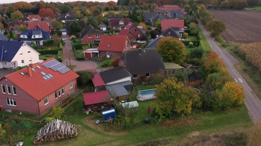 Ein Wohngebiet auf dem Land mit vielen Häusern und Gärten dicht beieinander.