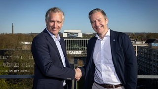Frank Baumann und Axel Hefer (Aufsichtsrat Schalke 04) schütteln sich die Hände.