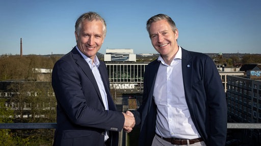 Frank Baumann und Axel Hefer (Aufsichtsrat Schalke 04) schütteln sich die Hände.