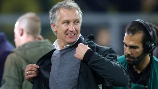 Werder-Geschäftsführer Frank Baumann zieht seine Jacke an.