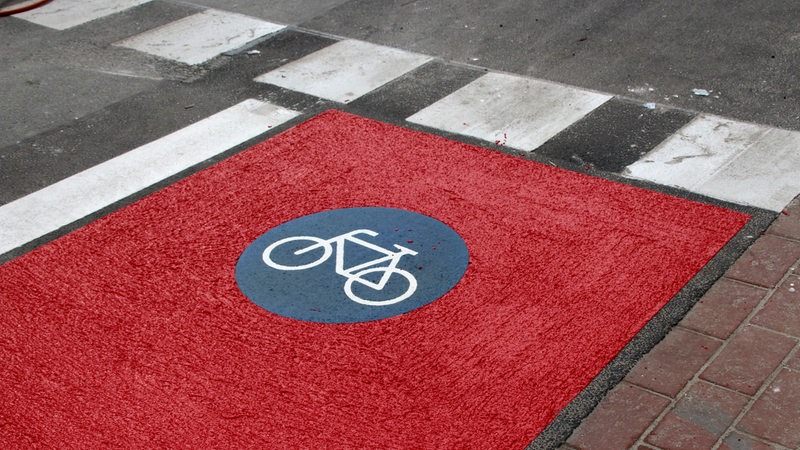 Ein Fahrrad-Symbol auf dem Boden des neuen Fahrradwegs in der Baustelle Herdentor.