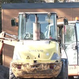 Ein Bagger steht auf der Baustelle eines Tiny House