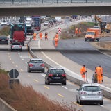 Bauarbeiter stehen in einer Baustelle auf der Autobahn A7.