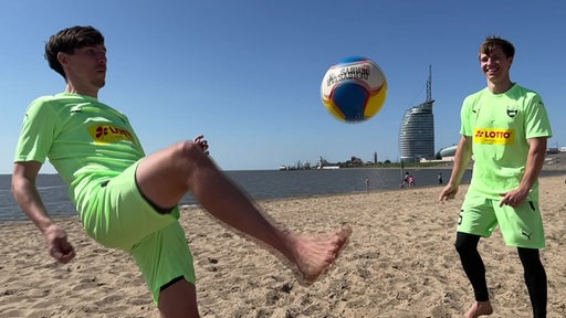Zwei Männer spielen Beachsoccer am Strand in Bremerhaven.