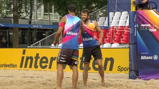 Zwei Beachvolleyballer auf dem Beachvolleyballfeld.