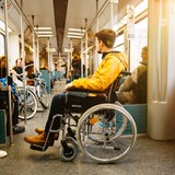 Ein junger Mann im Rollstuhl in einer S-Bahn.