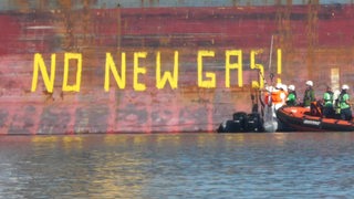Auf einer Bordwand von einem Schiff steht der Schriftzug "No New Gas".