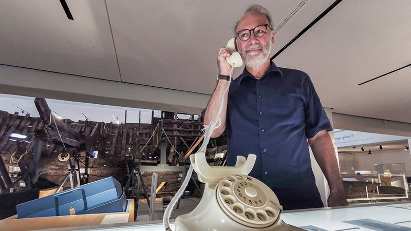 Kogge-Experte Bernd Wecker lauscht im Deutschen Schifffahrtsmuseum einer Telefonführung.